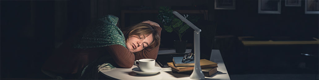 junge frau schlaeft am tisch