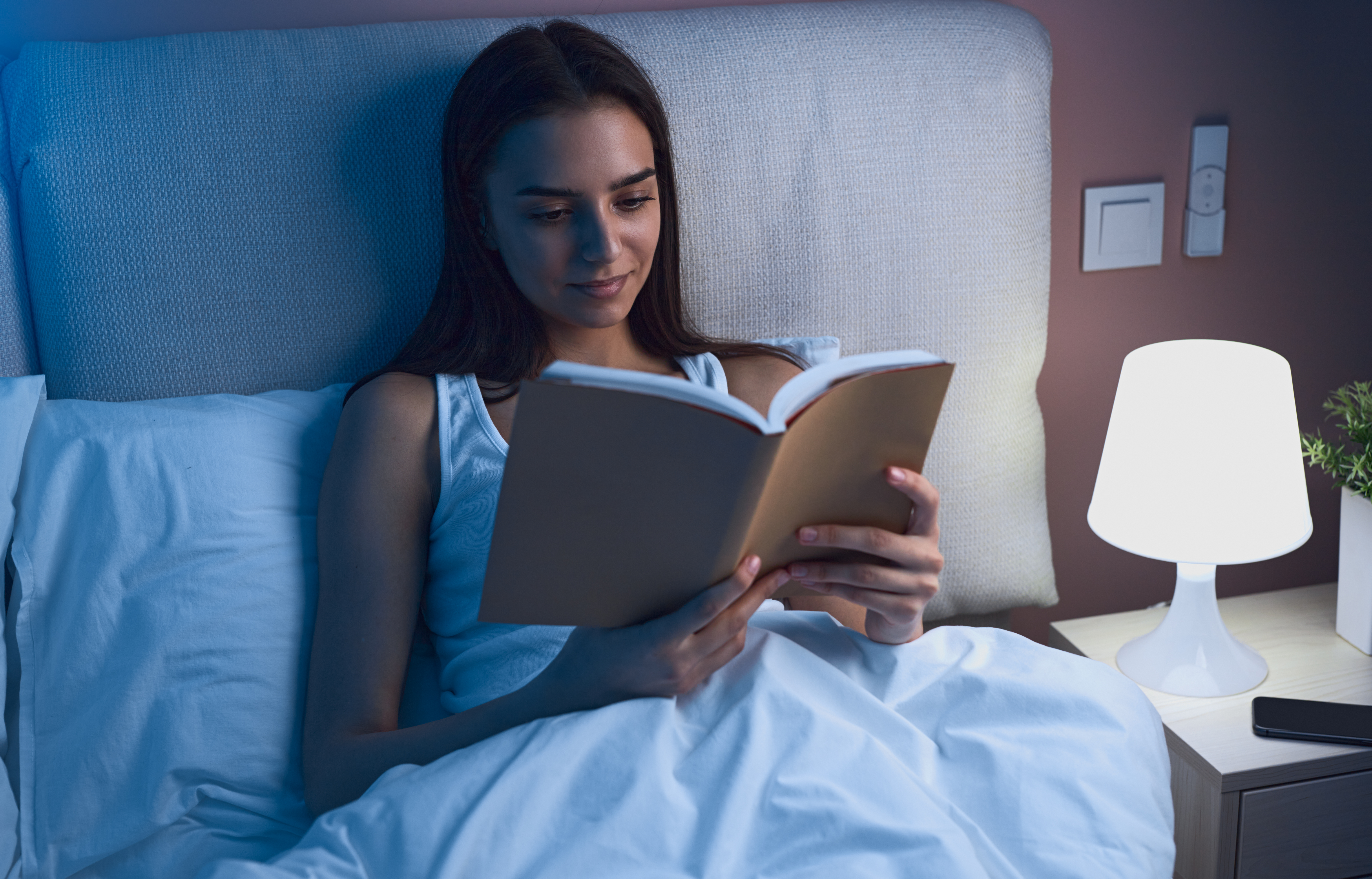 young-woman-reading-book-in-bed-at-night-2023-11-27-05-06-47-utc.jpeg