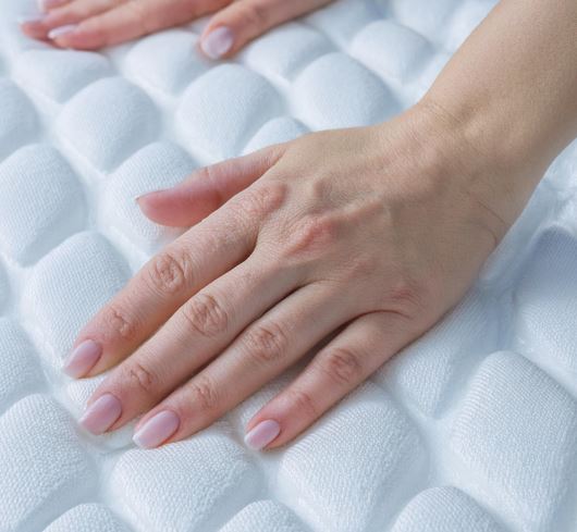 Frauenhände auf einer Kaltschaummatratze
